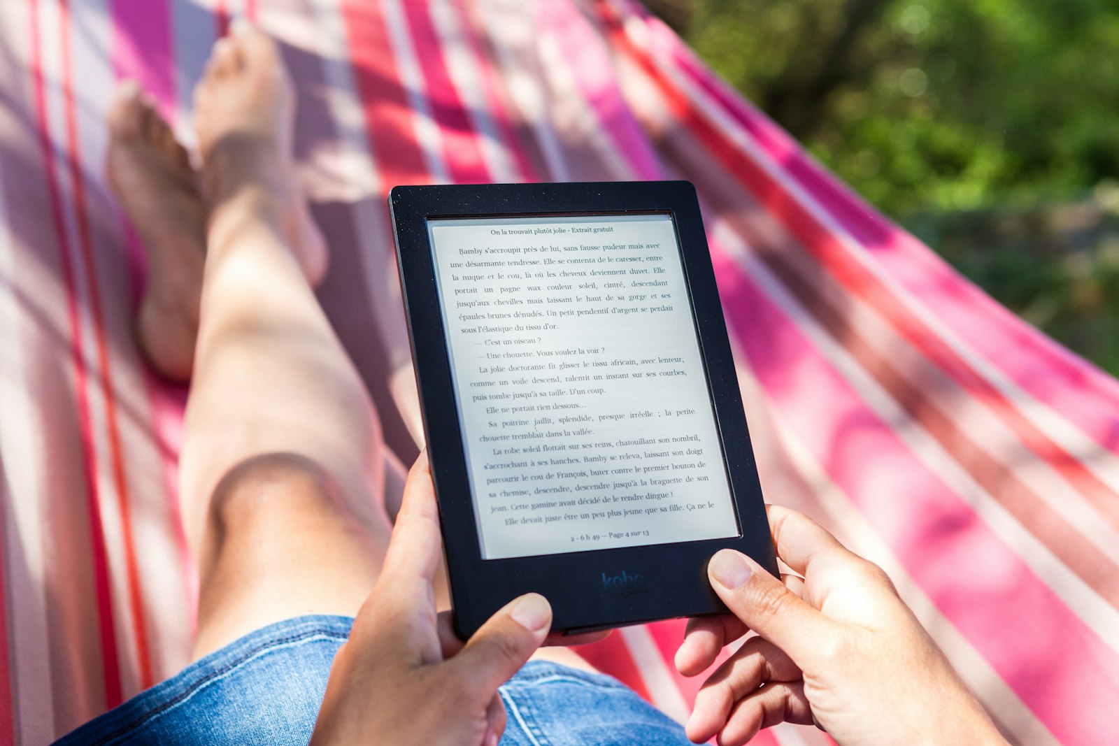 Someone reading on a Kobo in a striped hammock, bare feet up, trees behind: one photograph, across the four cards